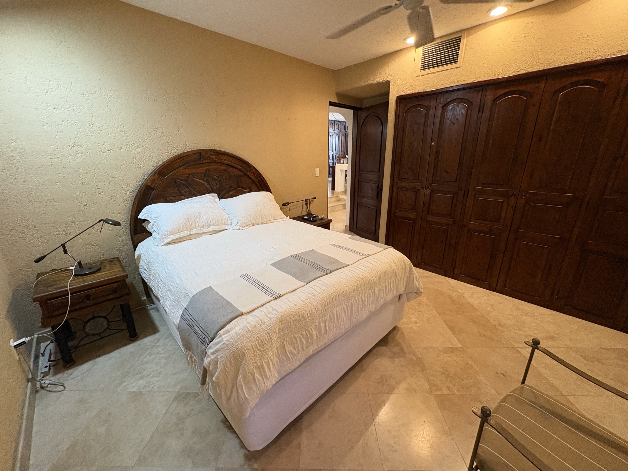 Bedroom with carved wood closet doors and furnished bed