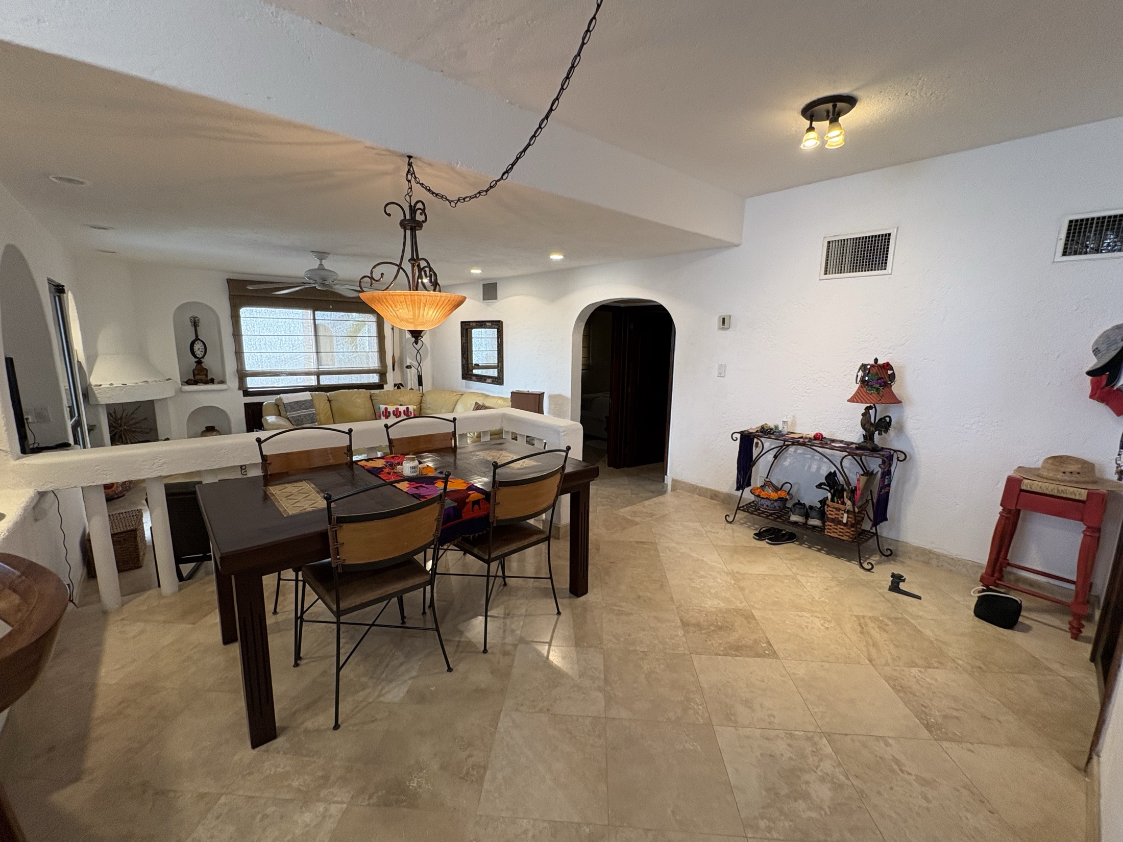 Dining area connected to kitchen and living room with travertine floors