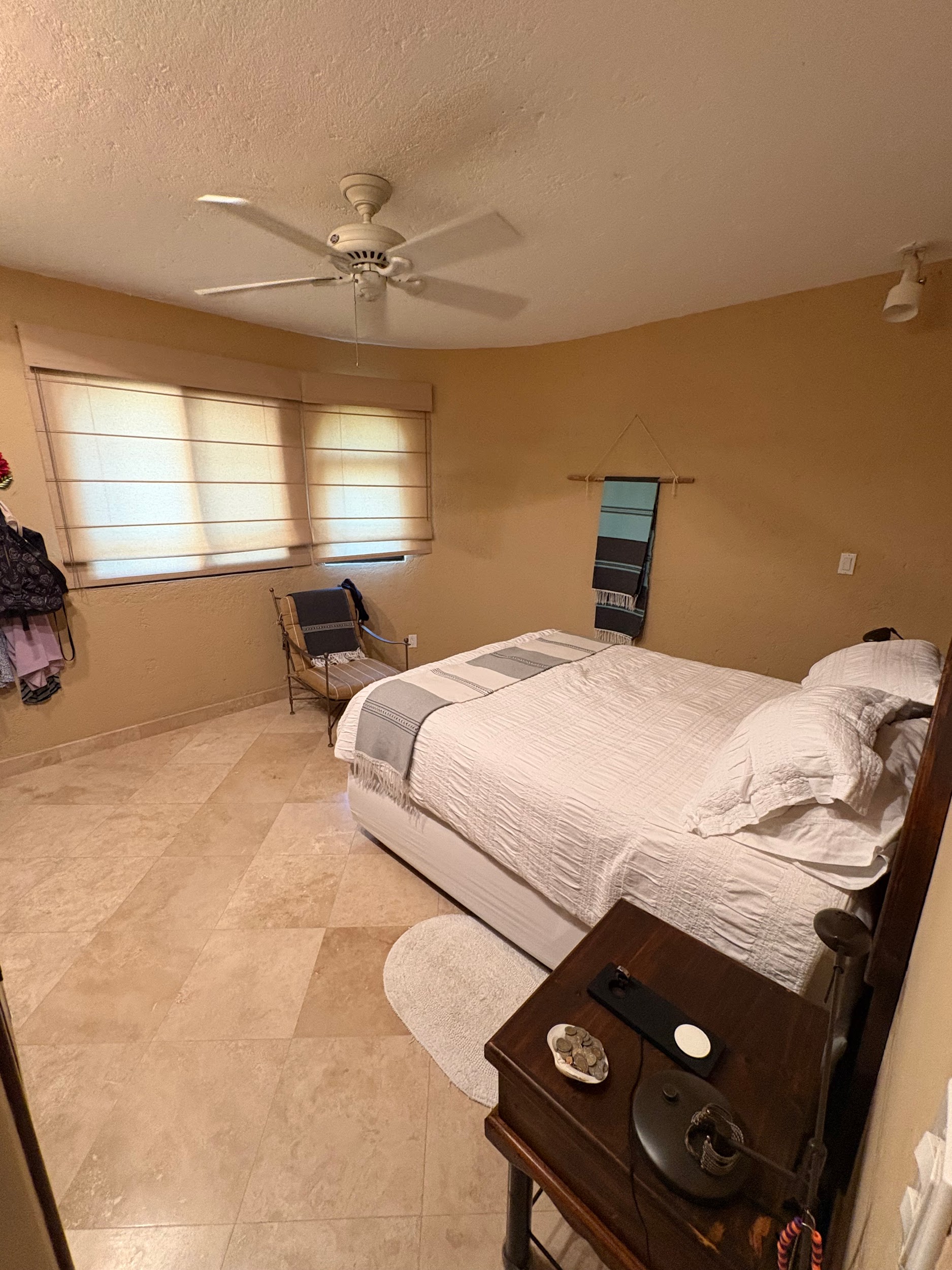 Bedroom with travertine floors and window blinds