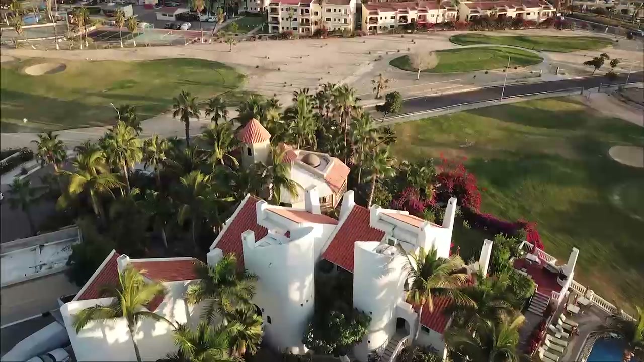 Aerial golf course view with Villas Baja rooftops and palms